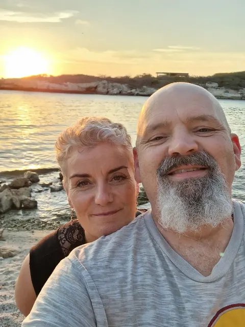 Charlie en Ilonka bij zonsondergang aan zee op Curaçao