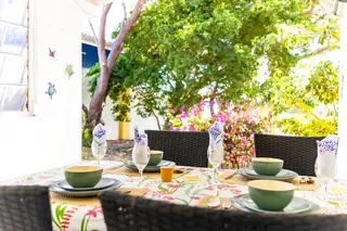 Gedekte tafel op de overdekte achterporch met tuinzicht