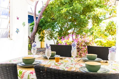 Gedekte tafel op de achterporch met tuinzicht