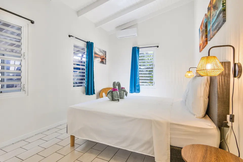 Slaapkamer 1 met kingsize bed, rieten wandlampen en airco